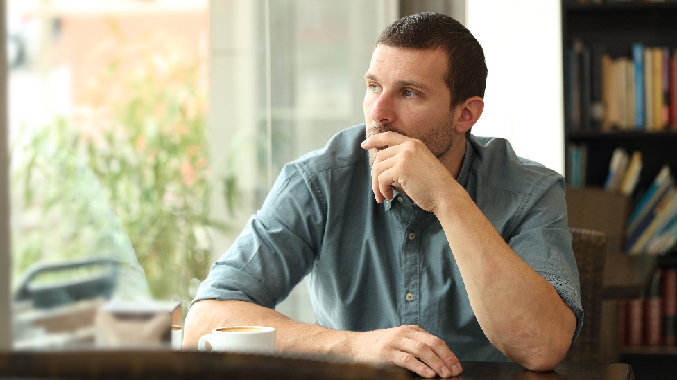 Mann im Konflikt: Will ich das Kind? (Quelle: Antonioguillem - stock.adobe.com) Mann im Café - schaut nachdenklich aus dem Fenster