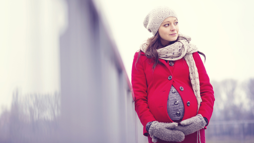 (Quelle: Thinkstock) Schwangere Frau fasst sich an ihren Bauch