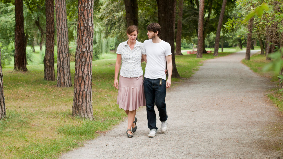 Paar spaziert Arm in Arm durch einen Park