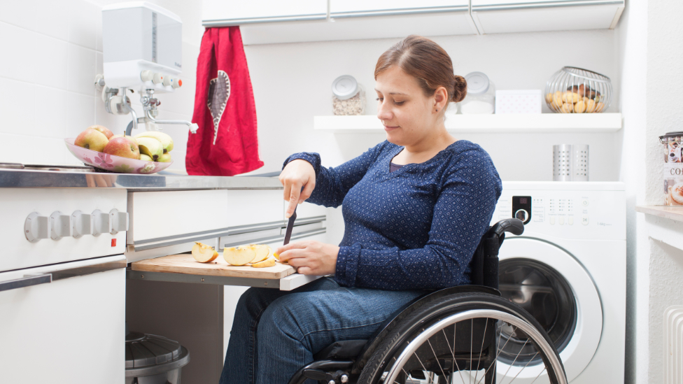 Gesund leben in der Schwangerschaft (Quelle: BIÖG/HN/Eichhöfer) Frau im Rollstuhl schneidet sich einen Apfel