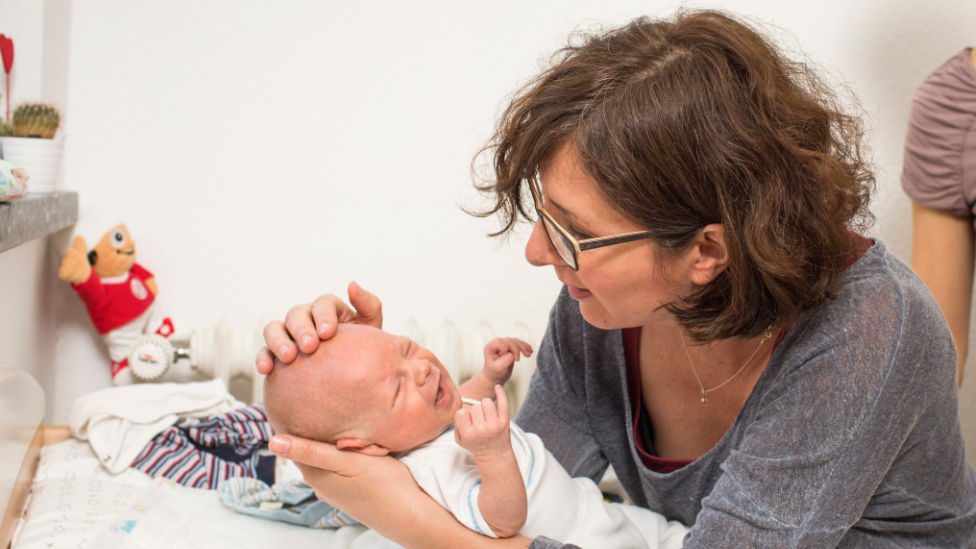 Familienhebamme bei der Betreuung eines Neugeborenen