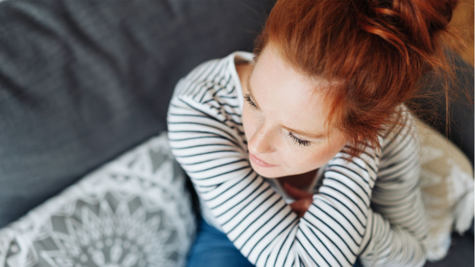 Wochenbett nach Fehlgeburt (Quelle: contrastwerkstatt/stock.adobe.com) Frau sitzt auf Sofa